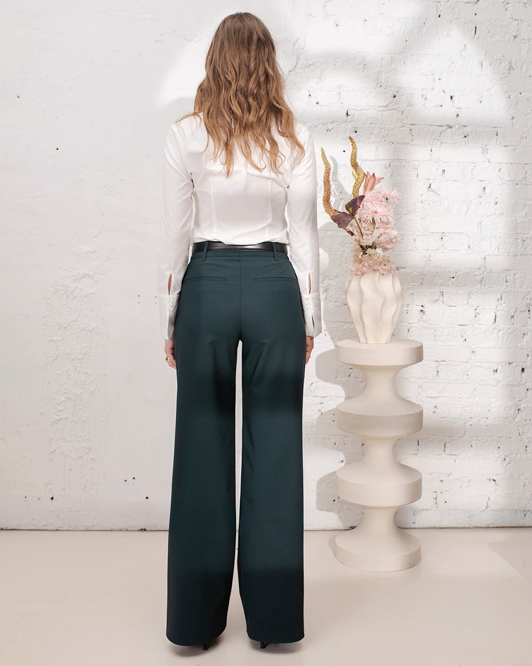 Veste cintrée vert bouteille avec pantalon large et gilet trois pièces pour un tailleur femme élégant.