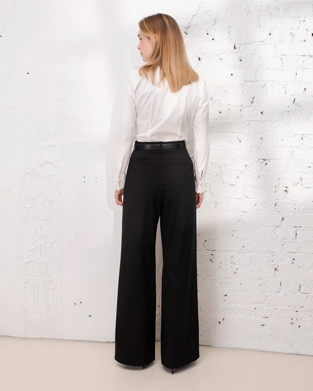 Tailleur femme pantalon noir avec chemise blanche cintrée pour une tenue professionnelle au bureau.