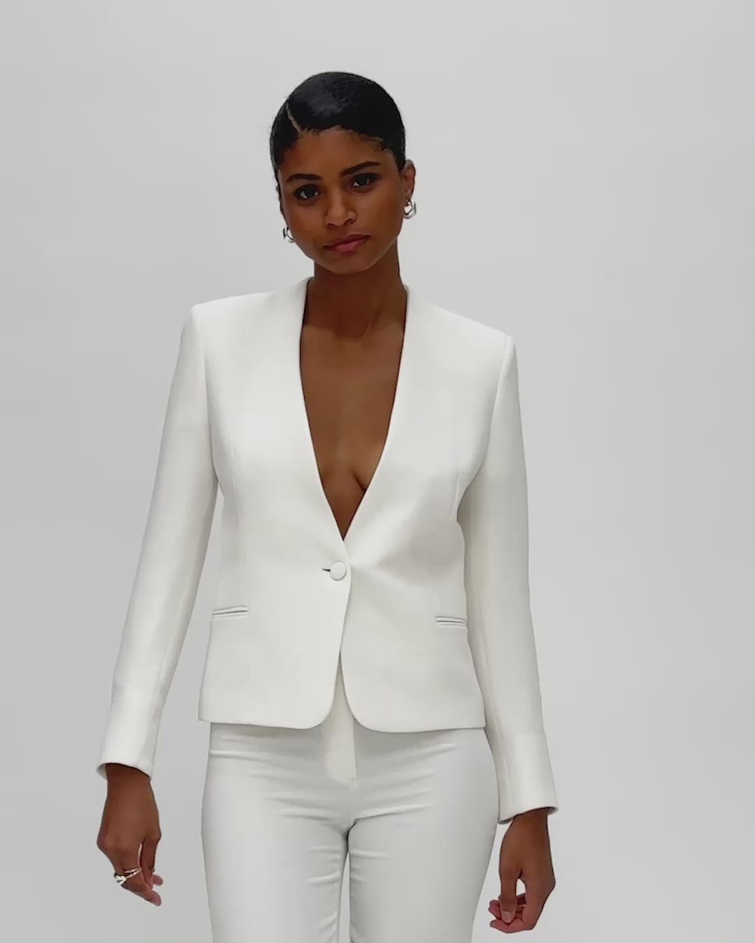 Tenue cérémonie femme avec veste courte blanche et pantalon cigarette blanc, style tailleur raffiné.