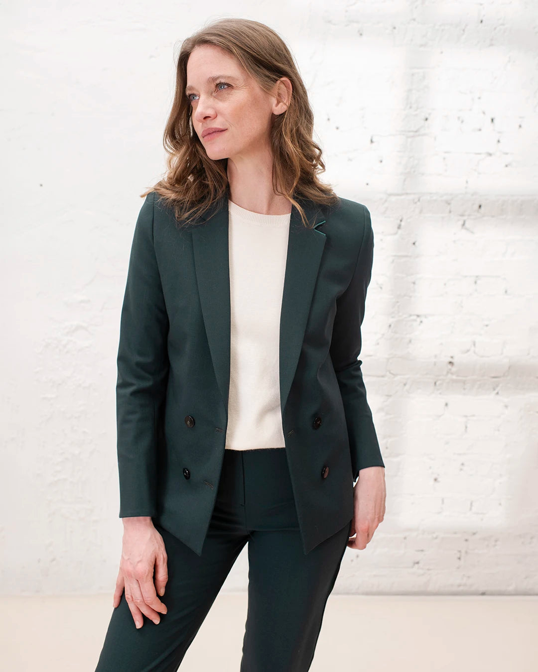 Look professionnel femme avec veste de tailleur croisée, chemise blanche et pantalon cigarette.
